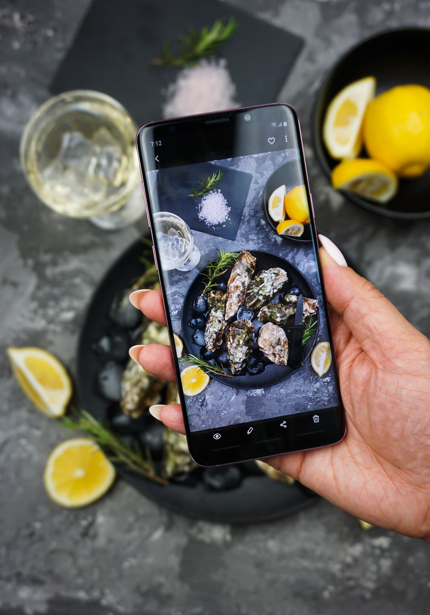 a girl takes off a table set with oysters in a restaurant on her phone