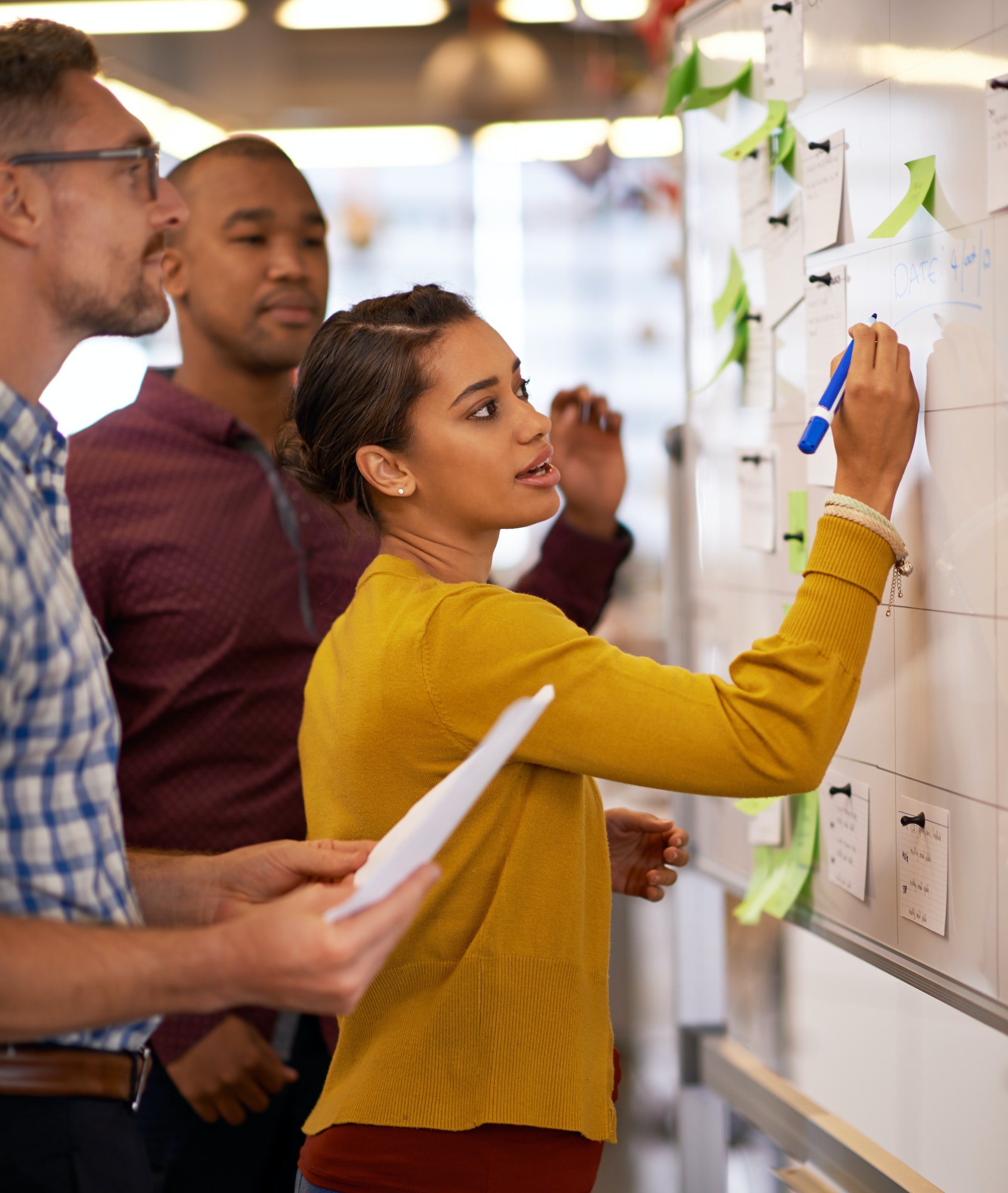 Considering some new strategies. Shot of a group of coworkers brainstorming at a whiteboard.