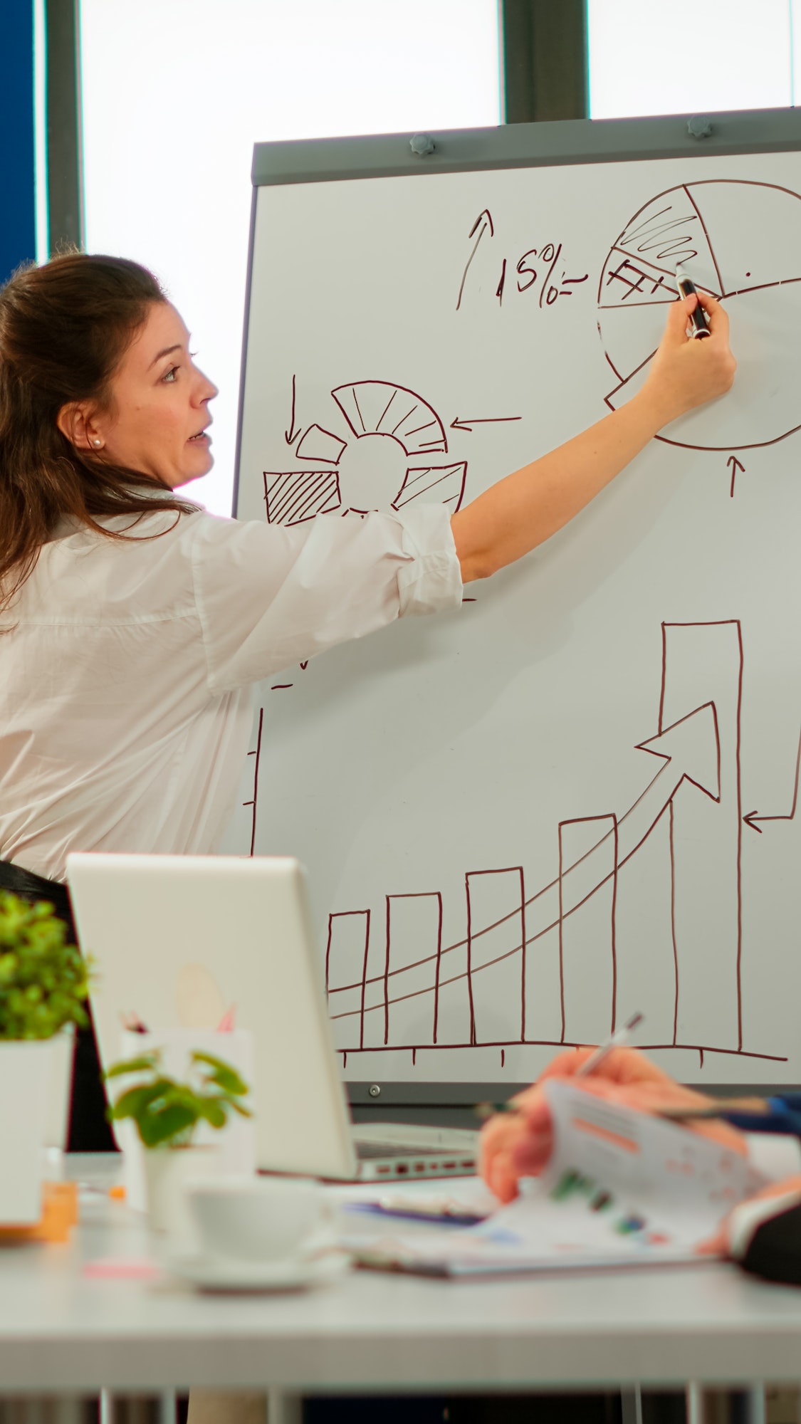 Focused team leader presenting marketing plan to interested multiracial coworkers